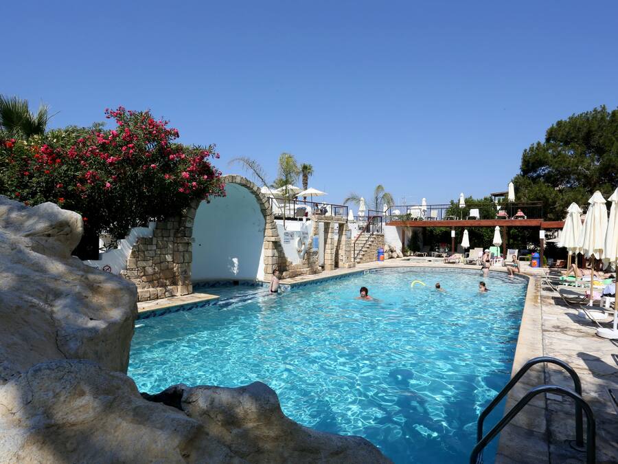 Una piscina al aire libre, sillones reclinables de piscina