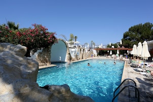 Una piscina al aire libre, sillones reclinables de piscina