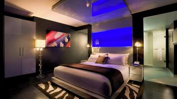 Ein modernes Hotelzimmer mit einem großen Bett, einem Flachbildfernseher und einem Teppich mit ZEBRA-MUSTER.