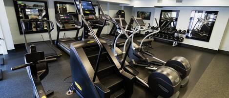 A gym with treadmills, elliptical machines, and free weights.