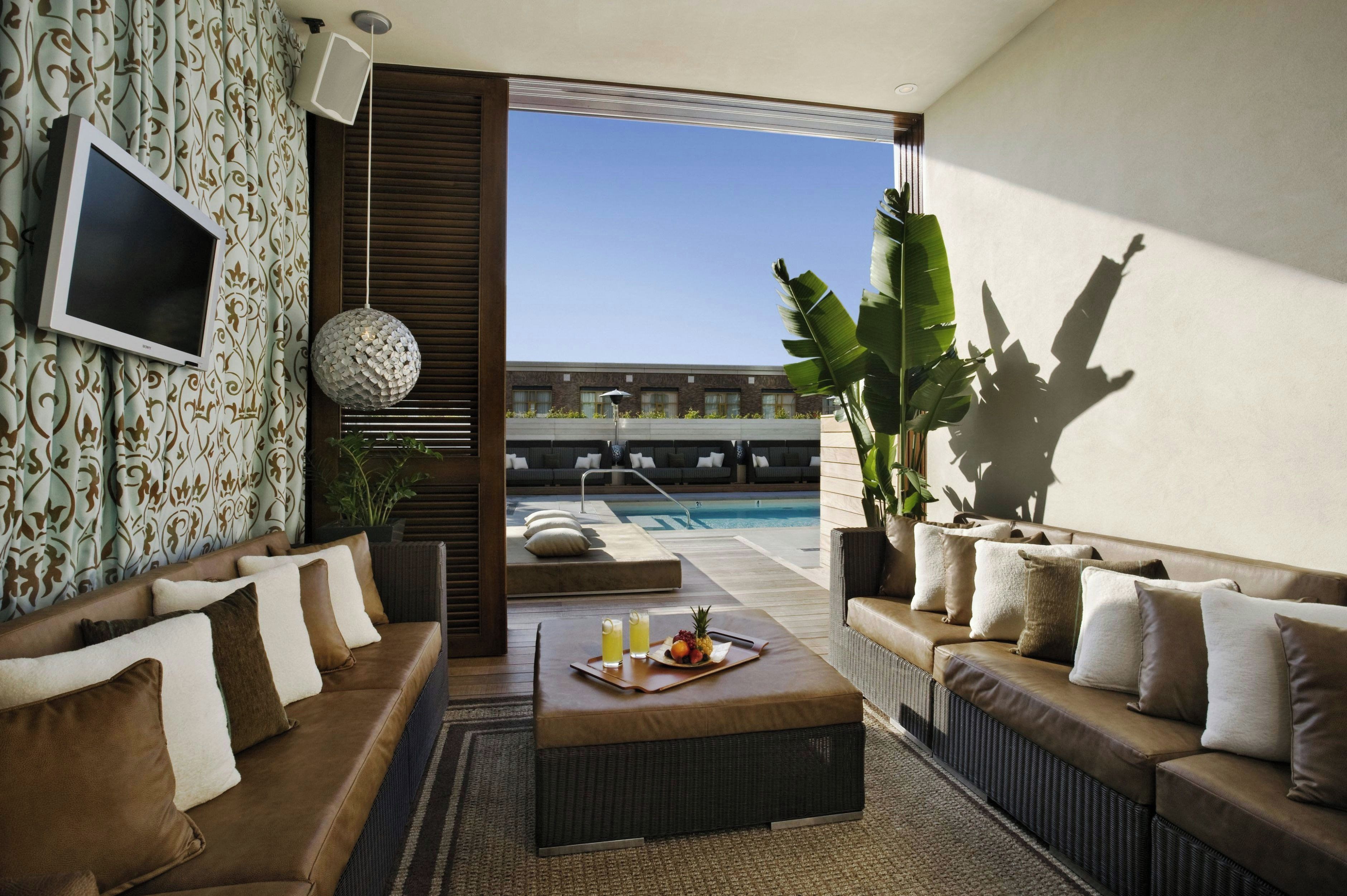 Un salon moderne avec vue sur la piscine, aménagé avec des canapés et une table basse.