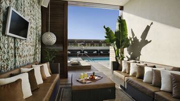 A modern living room with a pool view, furnished with sofas and a coffee table.