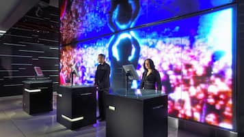 Un estudio moderno con dos presentadores en el atril, amplias pantallas LED al fondo y un diseño contemporáneo y elegante.