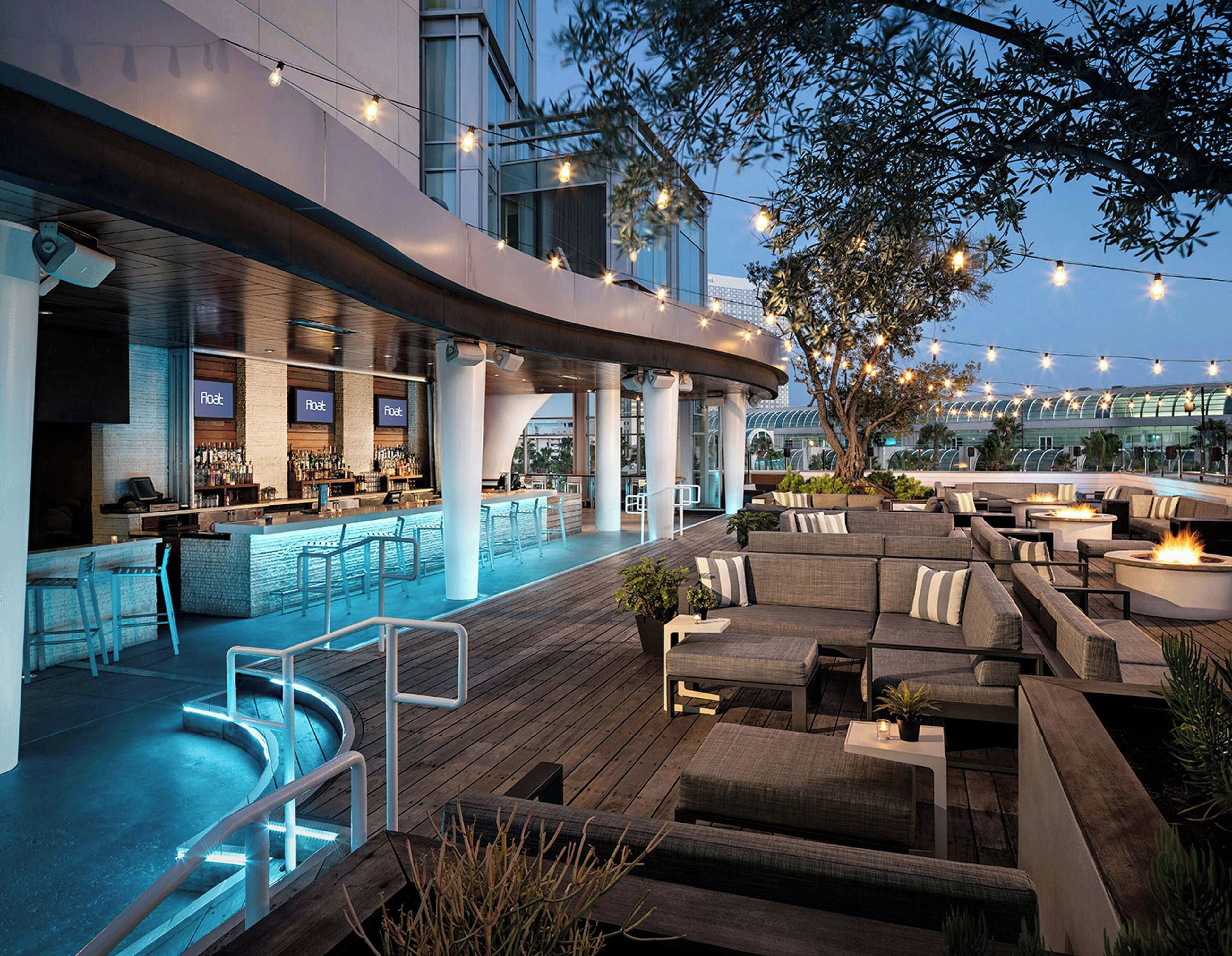 An outdoor bar area with seating and a pool.