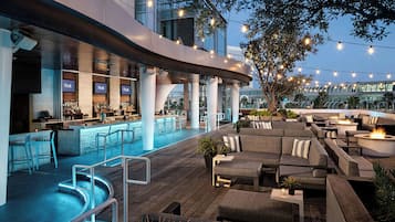 An outdoor bar area with seating and a pool.