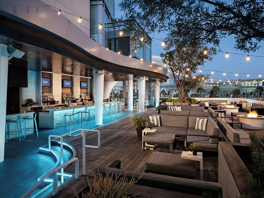 Un área de bar al aire libre con asientos y una piscina.