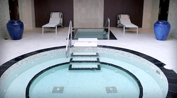 A modern hotel room with a large TV, a pool table, a sofa, and a bed. at Hard Rock Hotel & Casino Biloxi