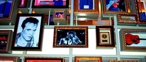 Una pared decorada con recuerdos enmarcados, incluyendo fotografías y objetos.