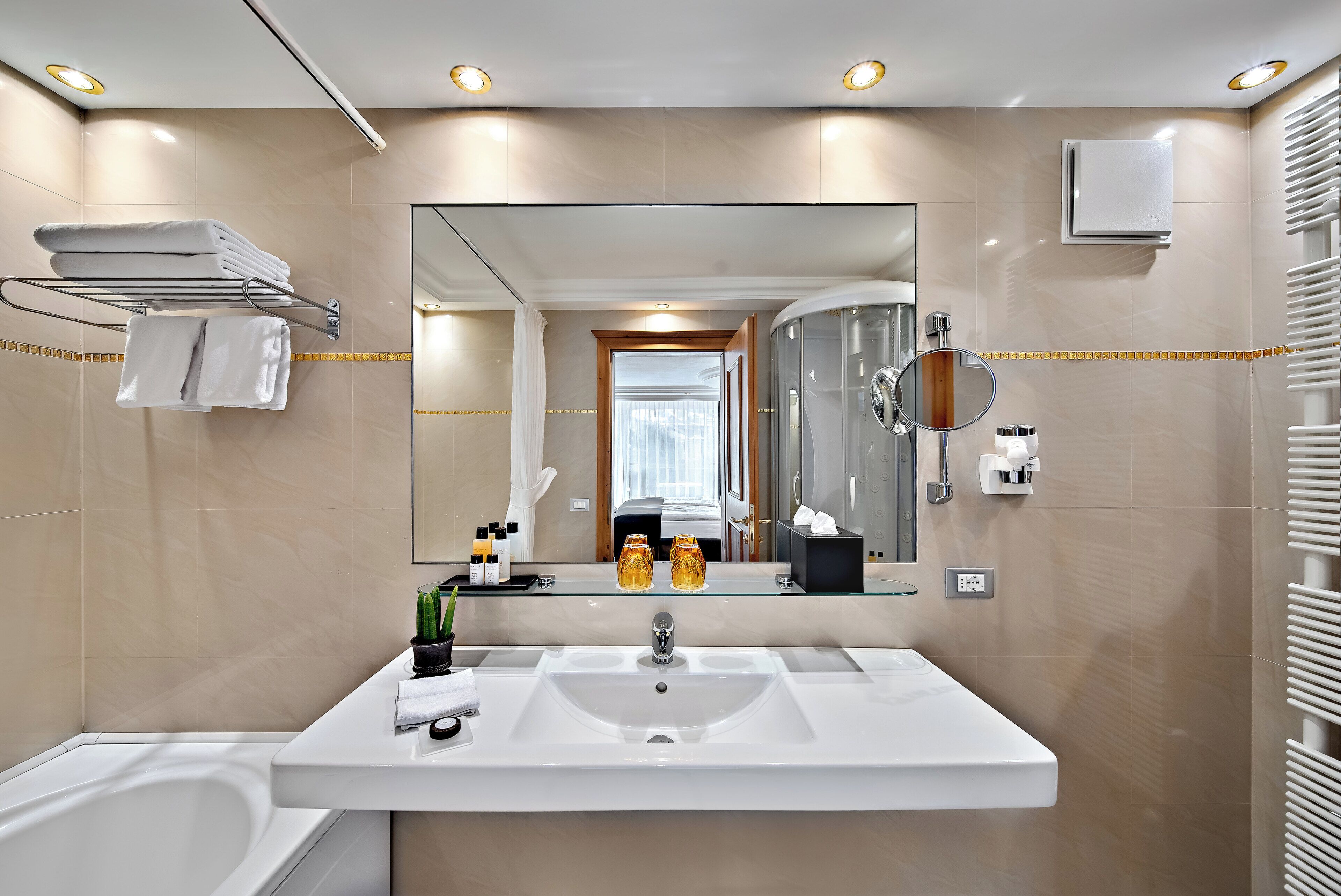 Un bagno moderno con un lavandino ampio, uno specchio e un portasciugamani.