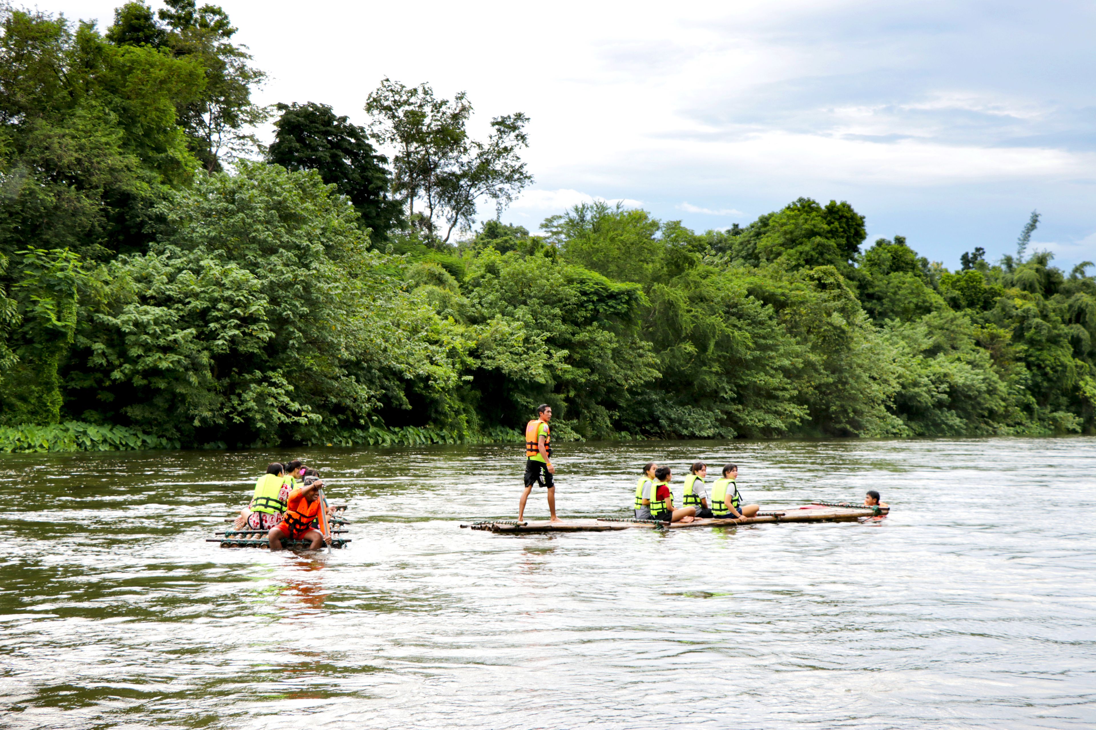 Un groupe de personnes se trouve sur une rivière, certaines étant à bord de bateaux et d’autres debout sur une plateforme.