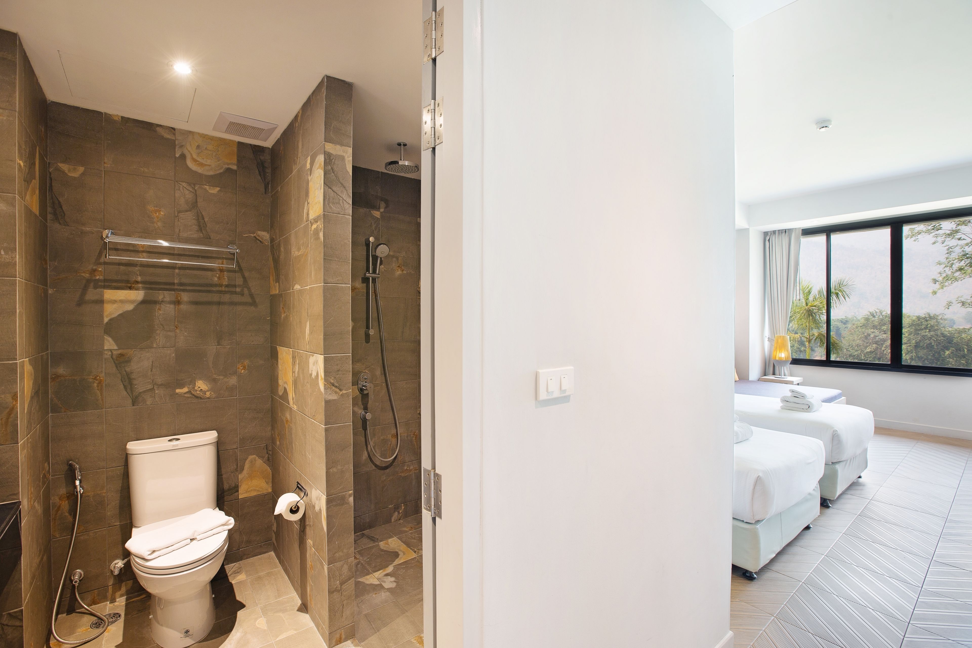 A modern bathroom with a shower, toilet, and a glass-enclosed shower area.