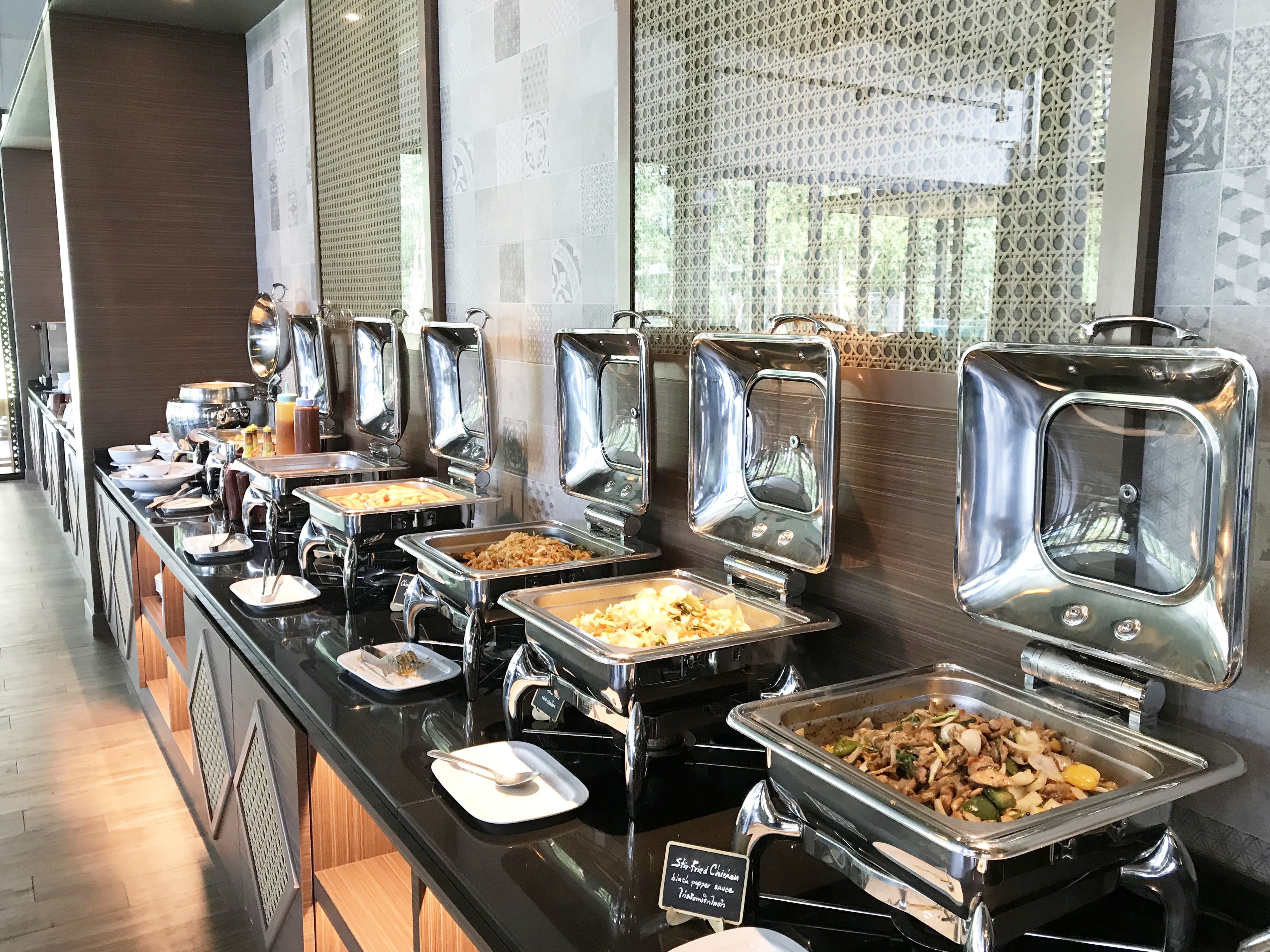 A buffet with various food options, including a sign indicating a spicy chicken dish.