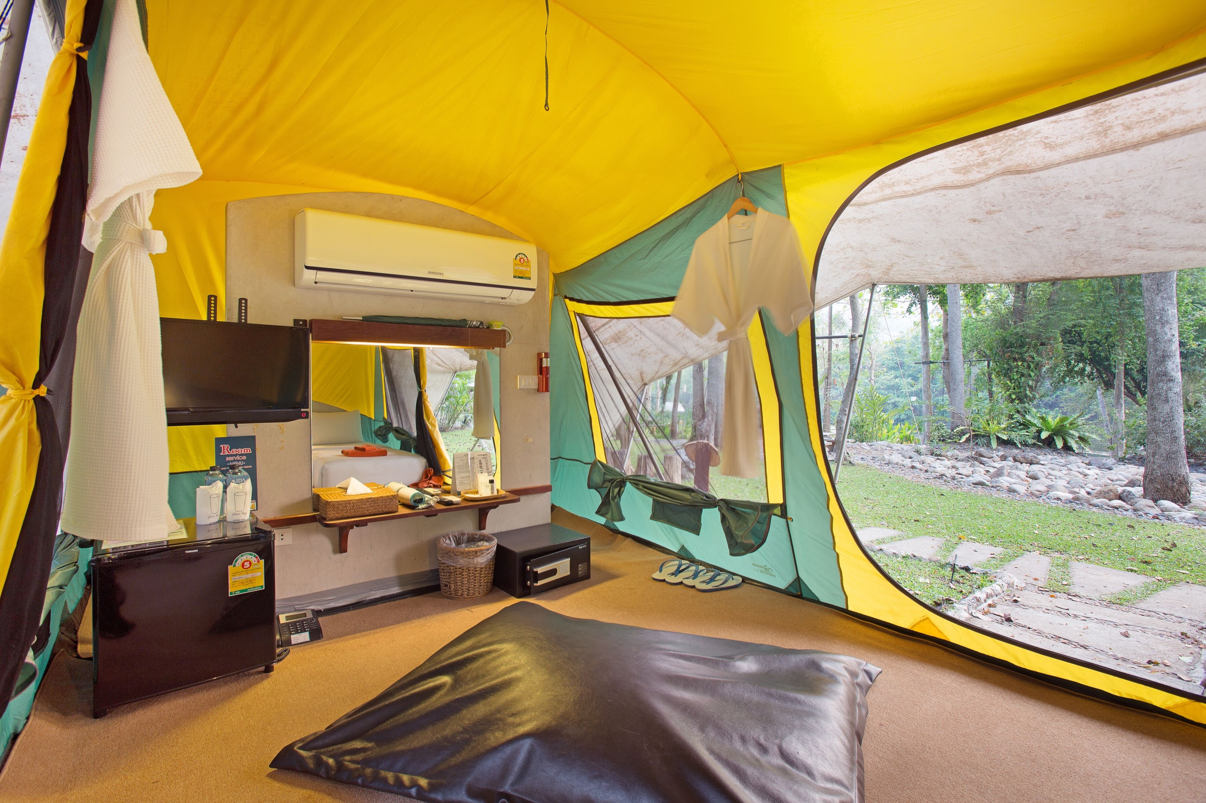 A tent with a kitchenette, including a sink, stove, and storage cabinets.