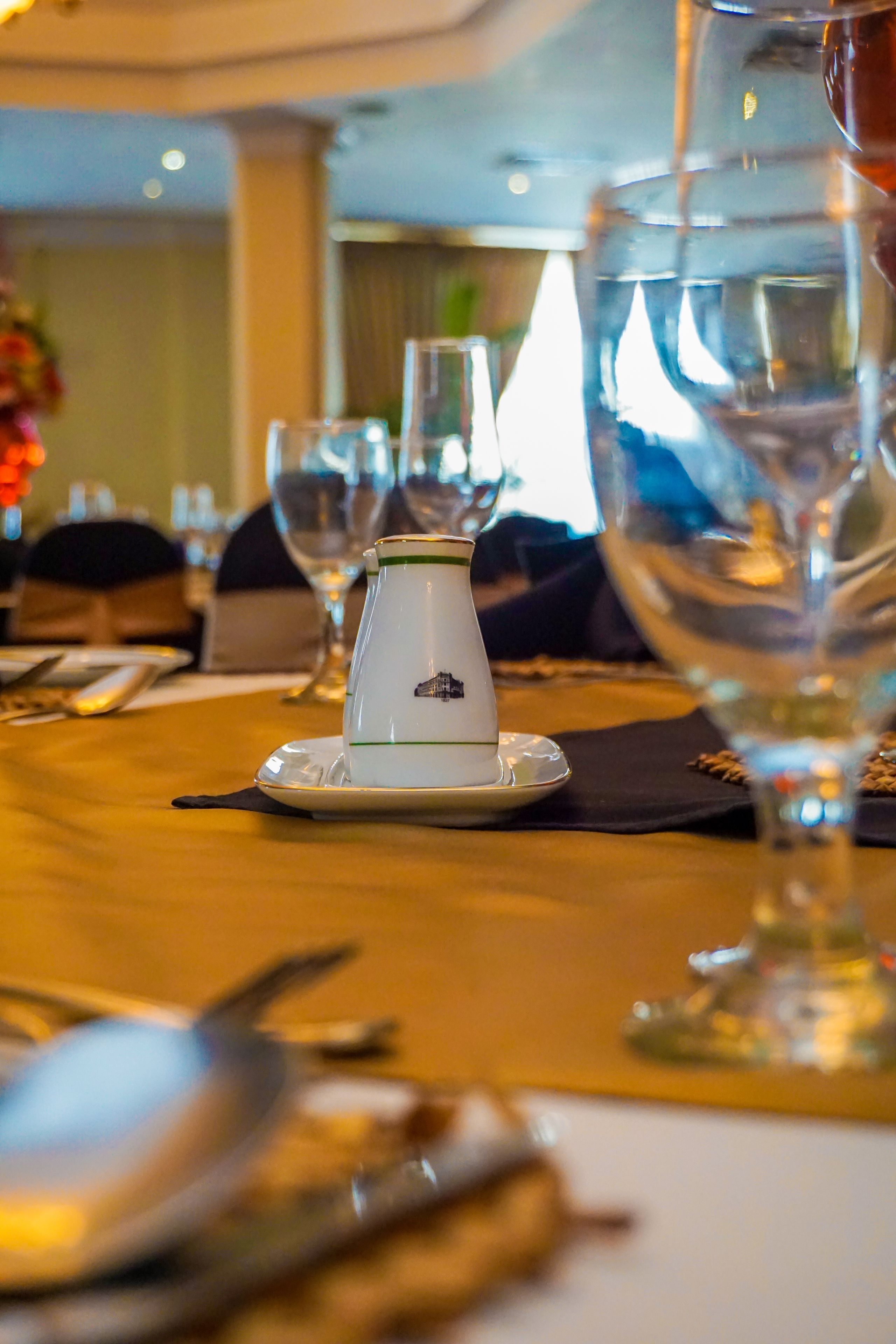 A dining table with a pitcher, glasses, and cutlery.
