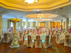 A banquet hall with round tables, white chairs, and floral centerpieces. - Grand Oriental Hotel (Colombo)