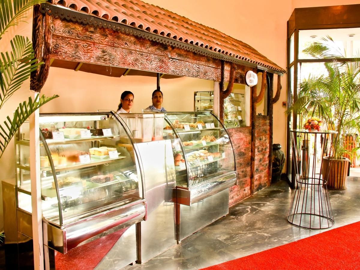 A bakery counter with pastries and a red carpet.