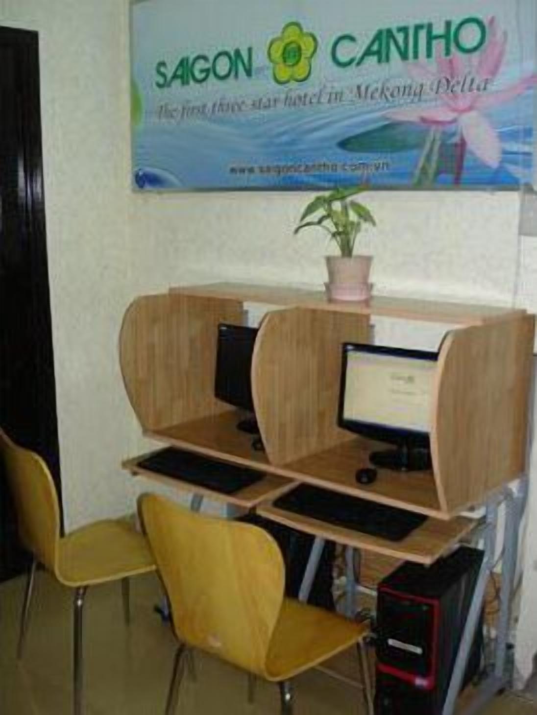 A computer desk with a monitor, keyboard, and a small potted plant.