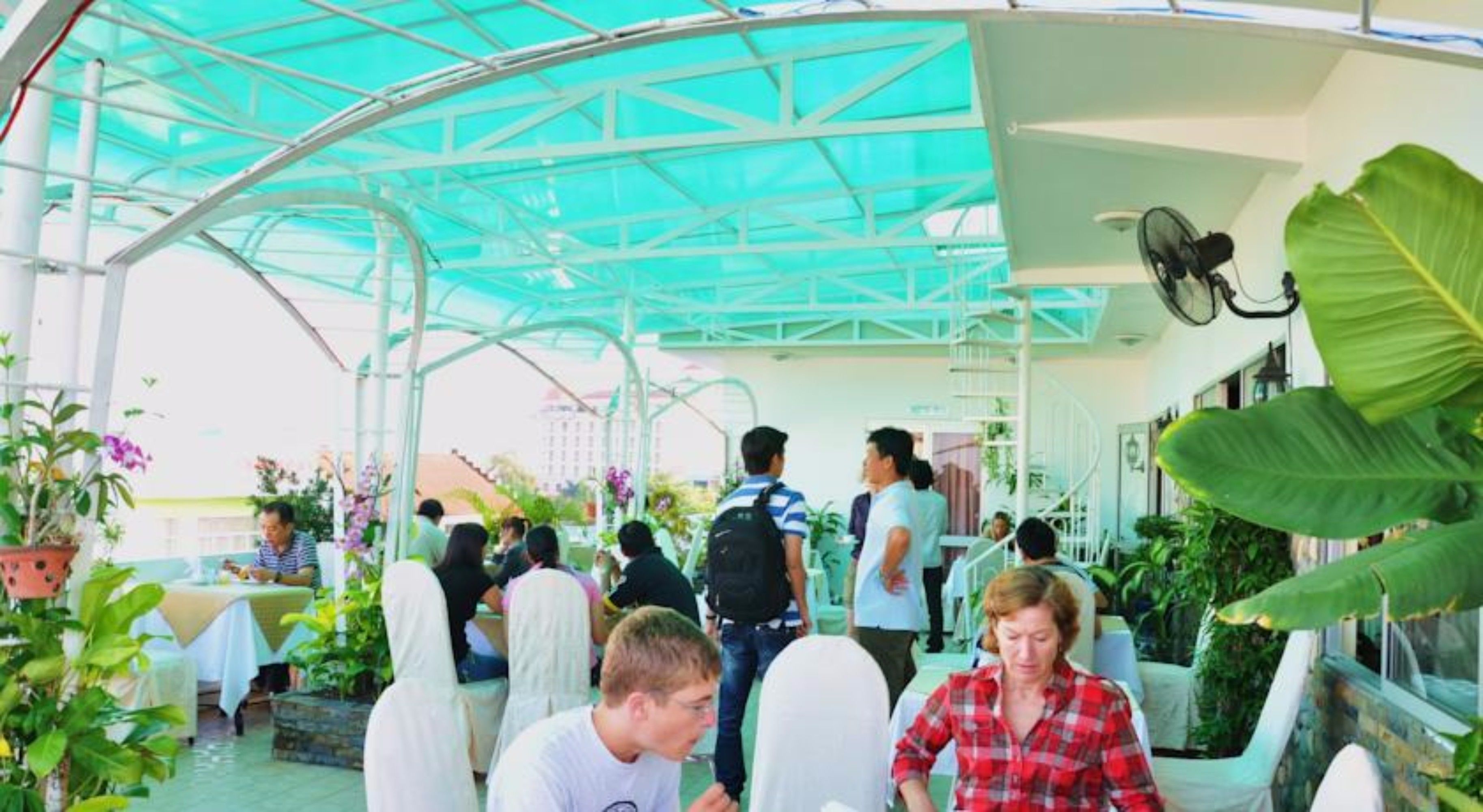 An indoor atrium with a glass ceiling, seating areas, and various plants.
