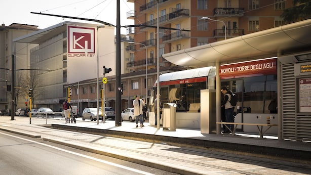 A train station platform with a tram stop, a pedestrian crossing, and a building with a sign reading "QUADRA KEY". - Quadra Key Easy Home In Florence (Florence)
