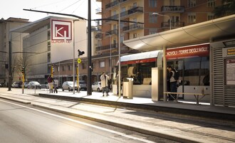 Un andén de estación de tren con una parada de tranvía, un paso de peatones y un edificio con un letrero que dice "QUADRA KEY".