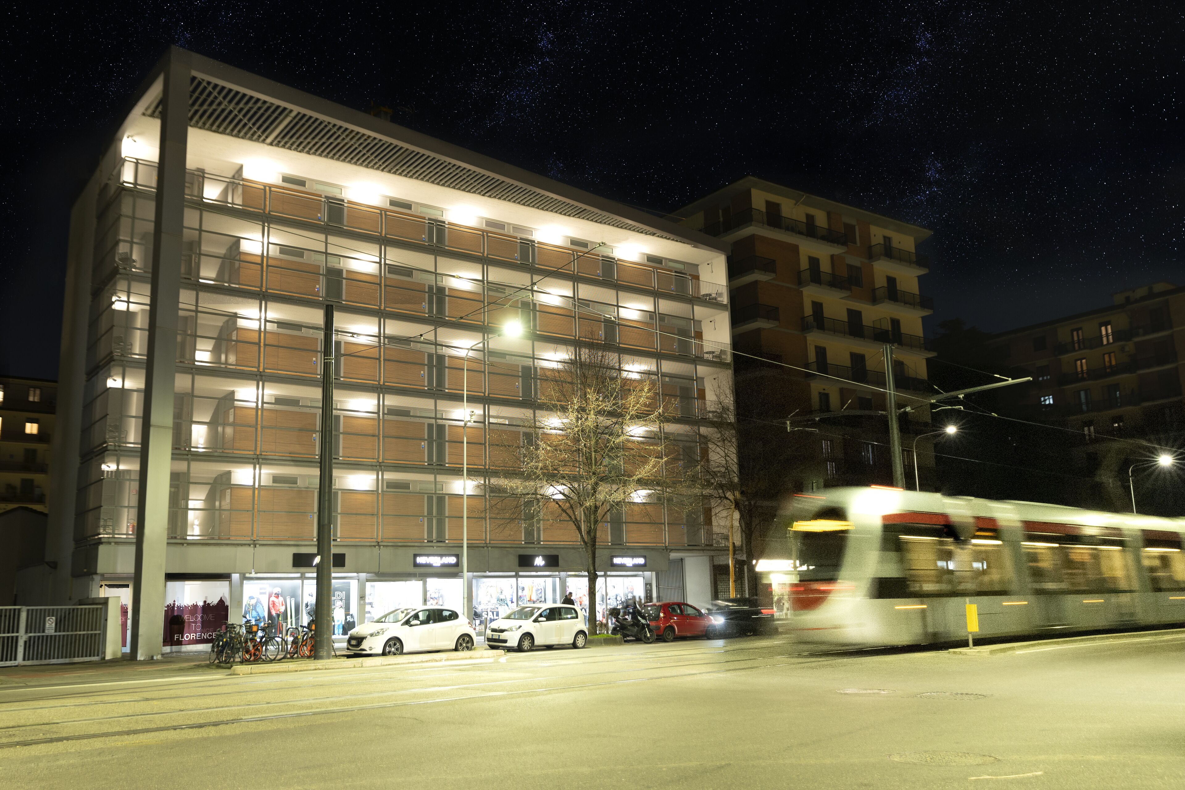 Um edifício de vários andares com design arquitetônico moderno, com grandes janelas e varandas.