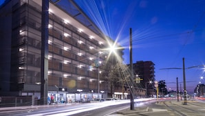 A modern building with multiple floors, large windows, and a ground-level entrance with shops. - Quadra Key Easy Home In Florence (Florence)