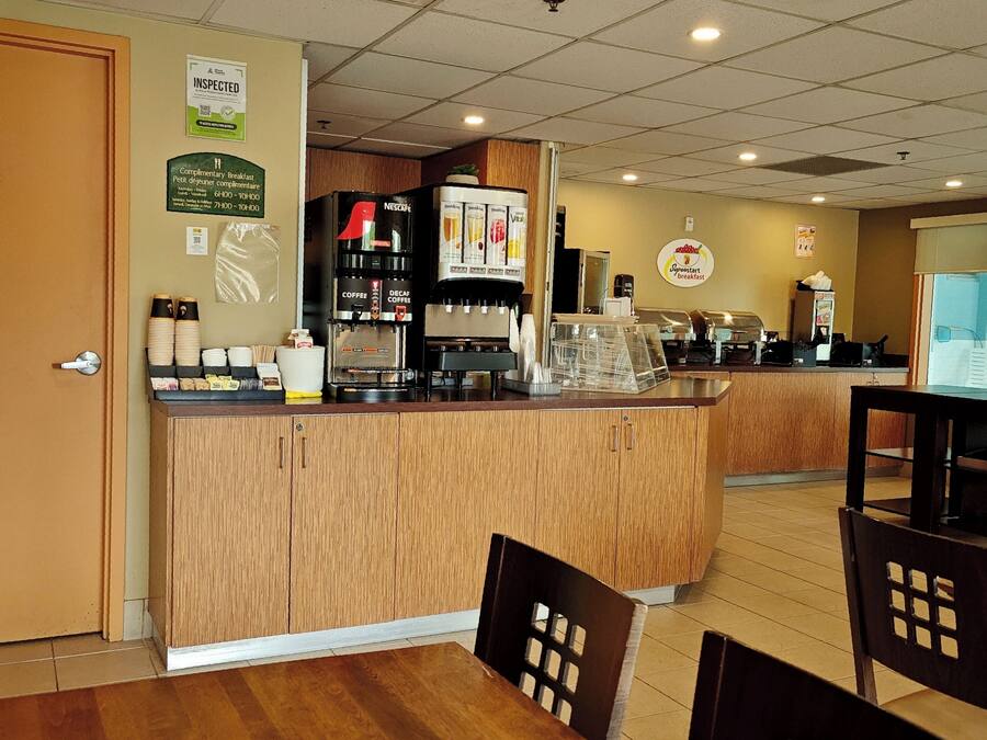 Un café con mostrador de madera, máquinas de café y zona de estar.