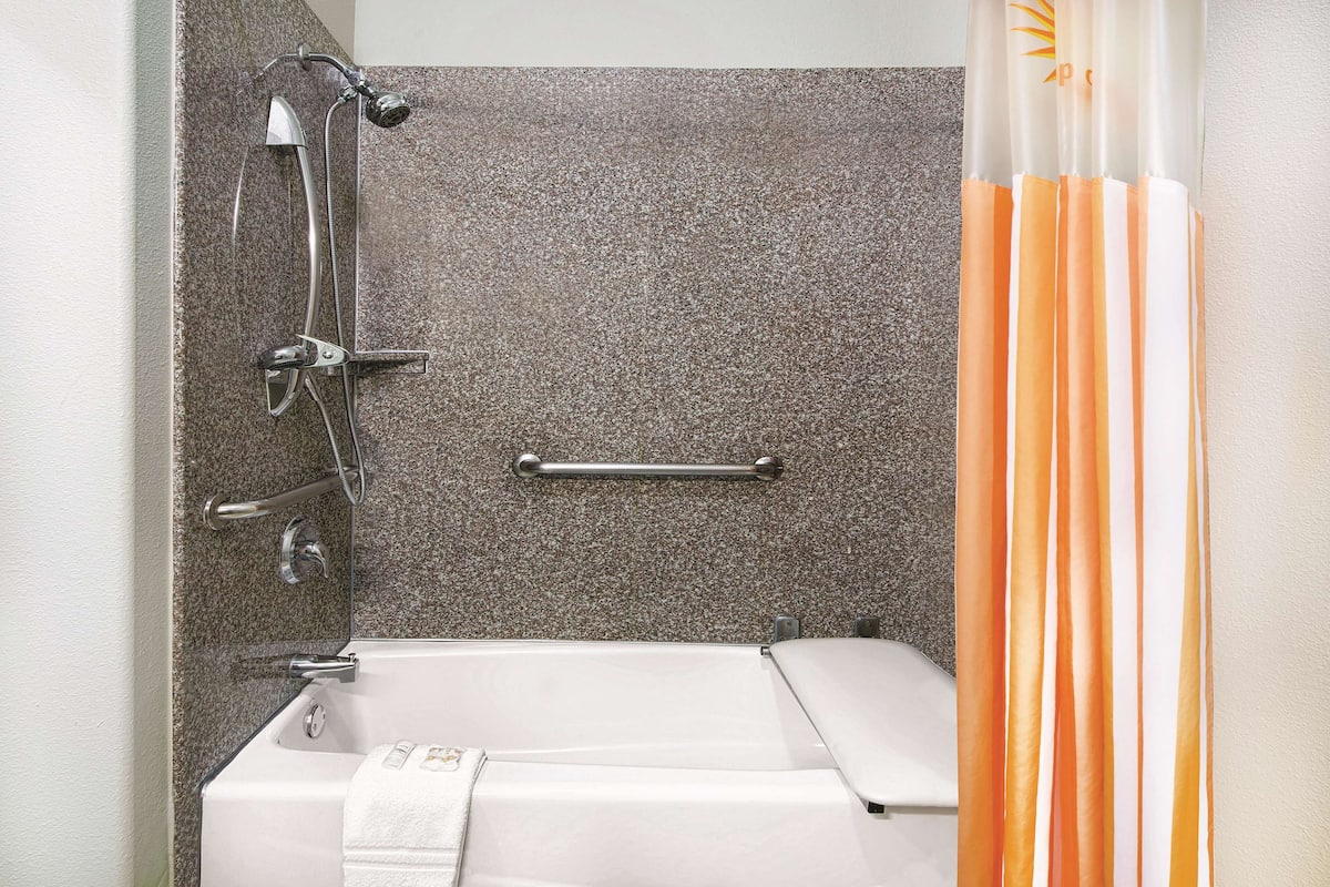A bathroom with a bathtub, a shower, and a towel rack.