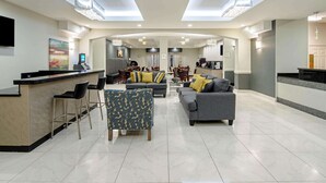 A spacious living area with a kitchen, bar area, and seating. - La Quinta Inn & Suites by Wyndham Mercedes Outlet Mall (Mercedes)