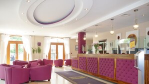 A lobby with a reception desk, seating area, and a decorative rug.