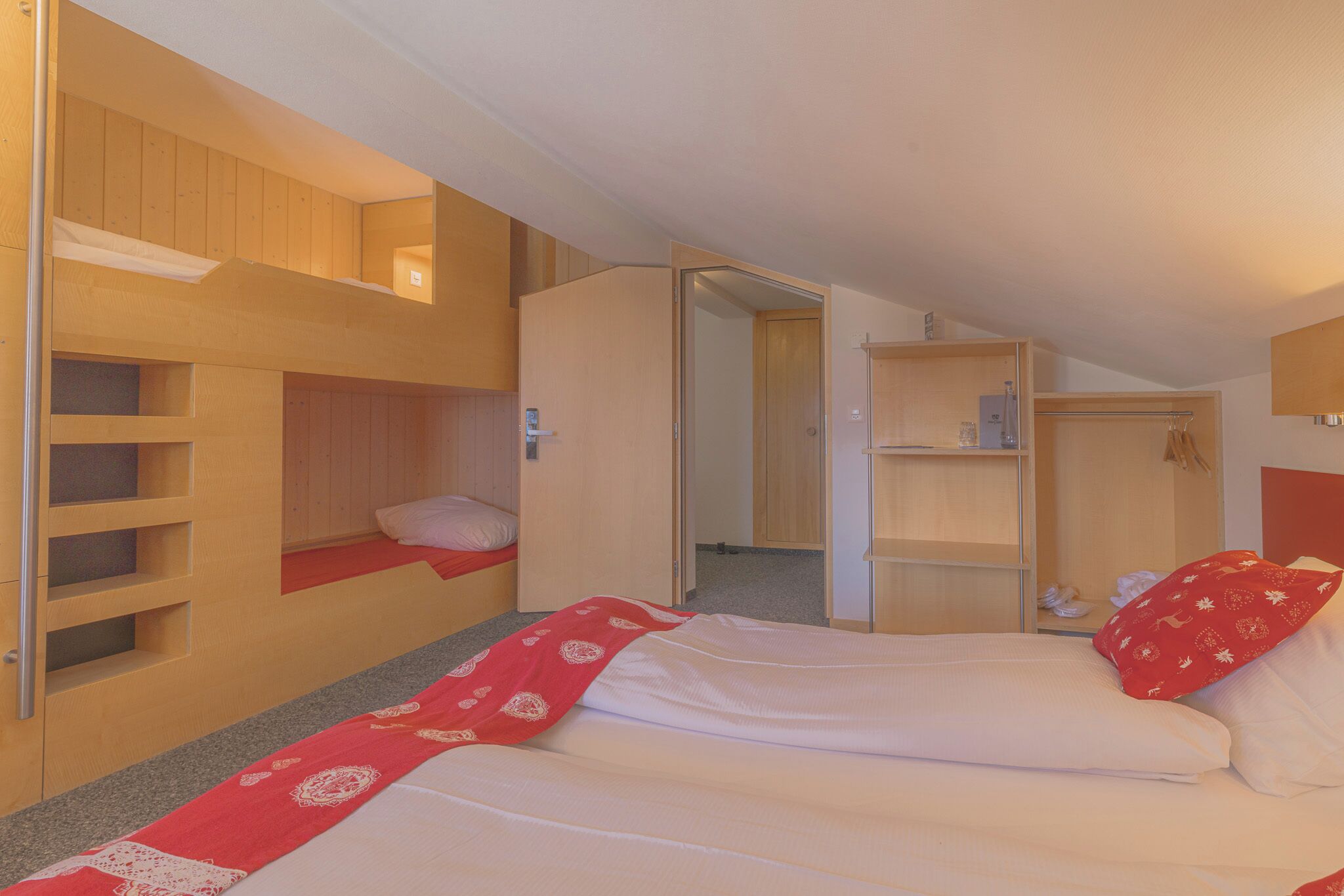 A room with bunk beds, a single bed, and a walk-in closet.