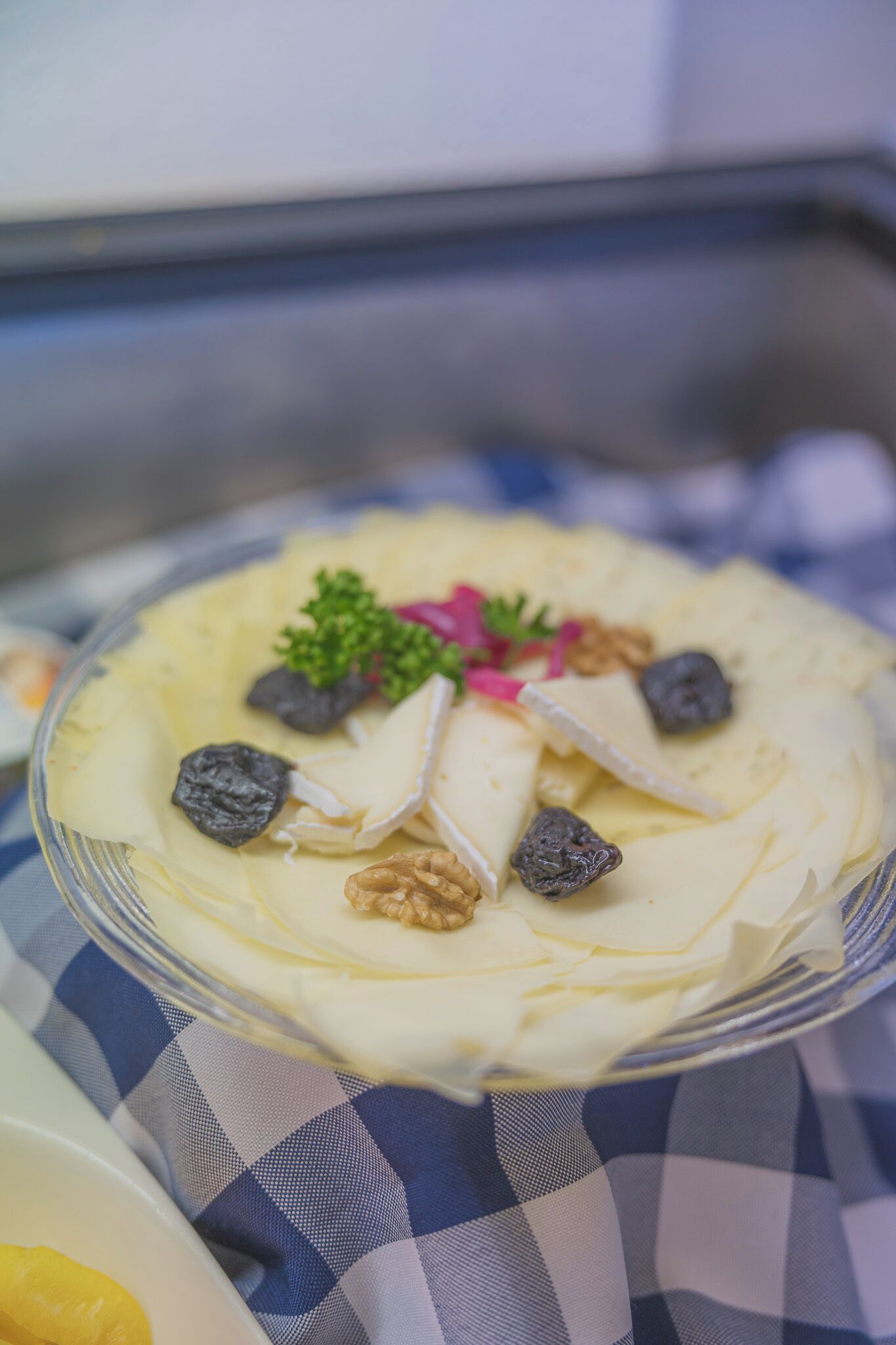Un dessert à base de crème, de noix et de fruits rouges, servi dans une assiette en verre.