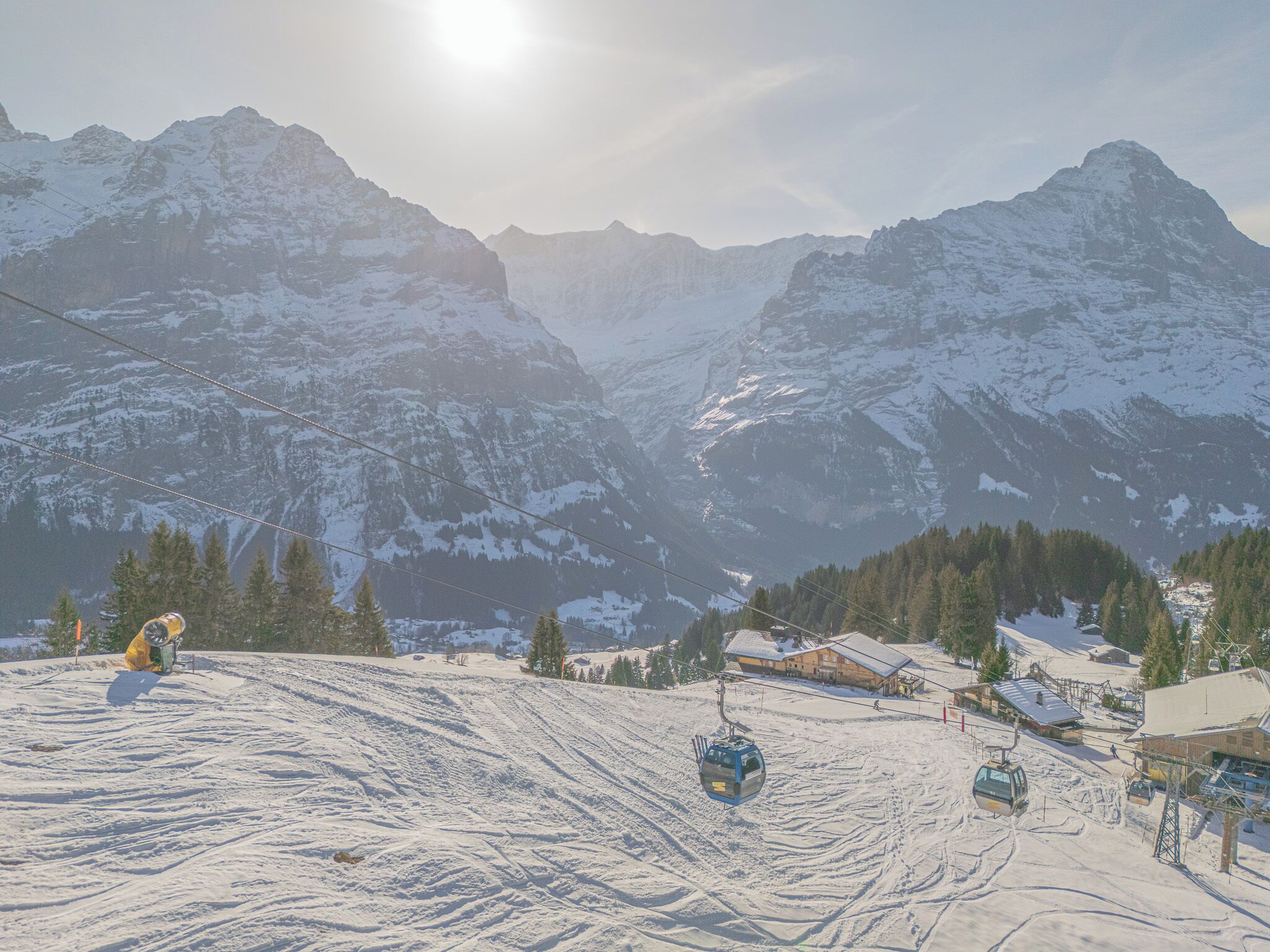 A snow-covered mountain landscape with a ski lift and buildings at the base.