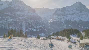 A snow-covered mountain landscape with a ski lift and buildings at the base.
