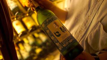 A person holding a bottle of wine with a label that includes the year 2005.