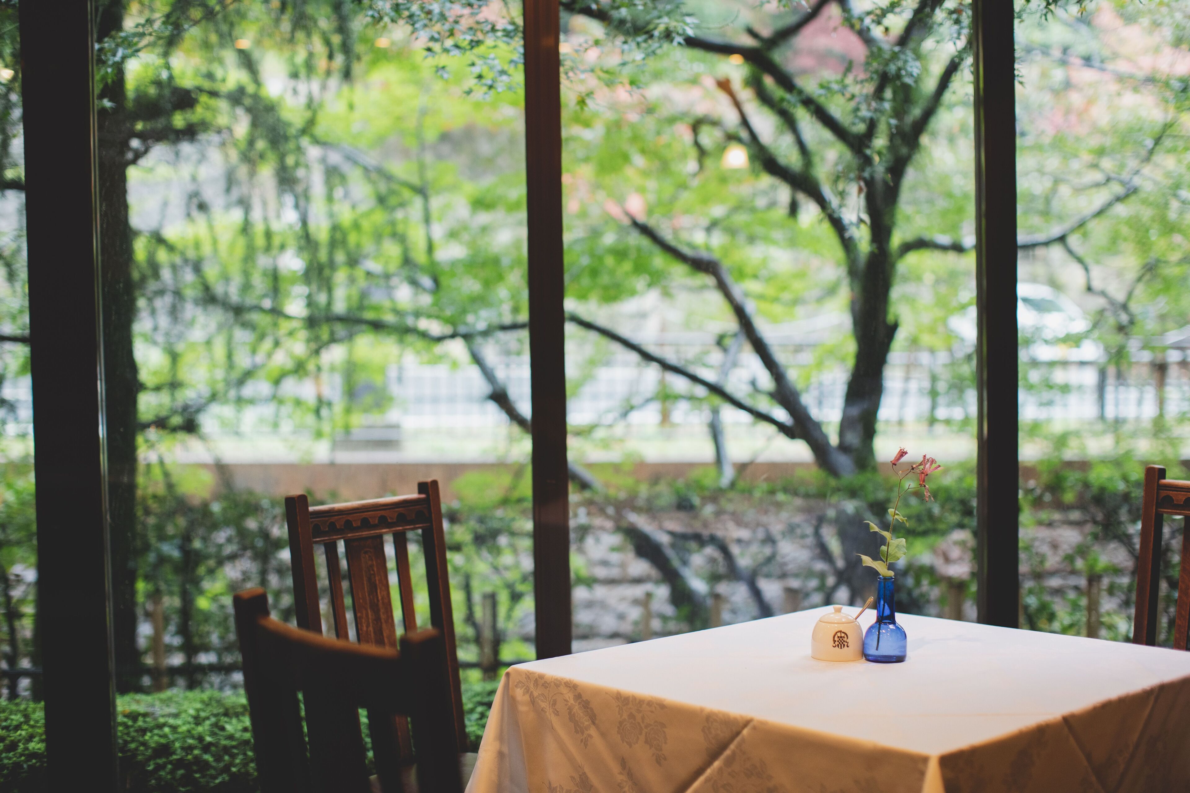 A table with a tablecloth, a vase with flowers, and a small container with a logo.
