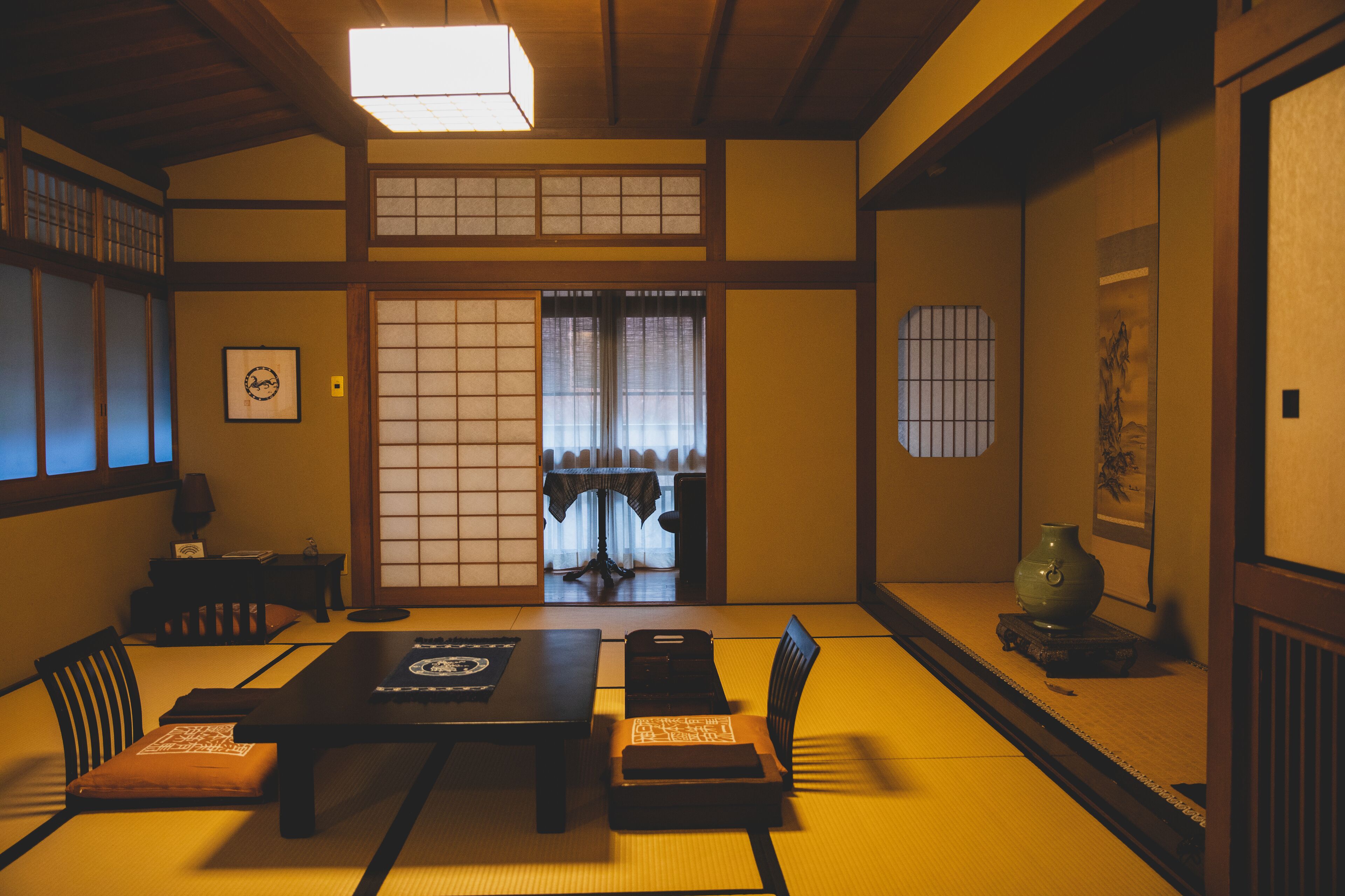 A traditional Japanese room with tatami flooring, a low table, and shoji screens.