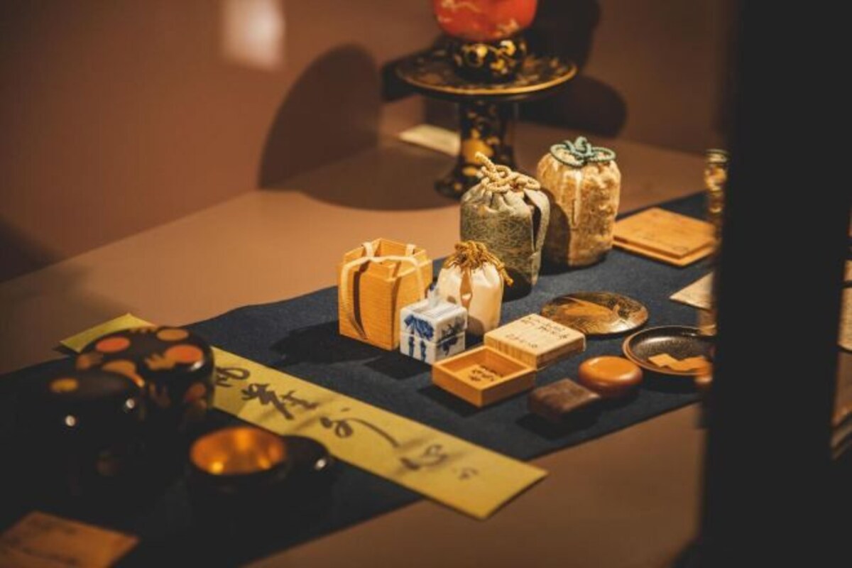A table with various items including wrapped gifts, a candle, and a menu.