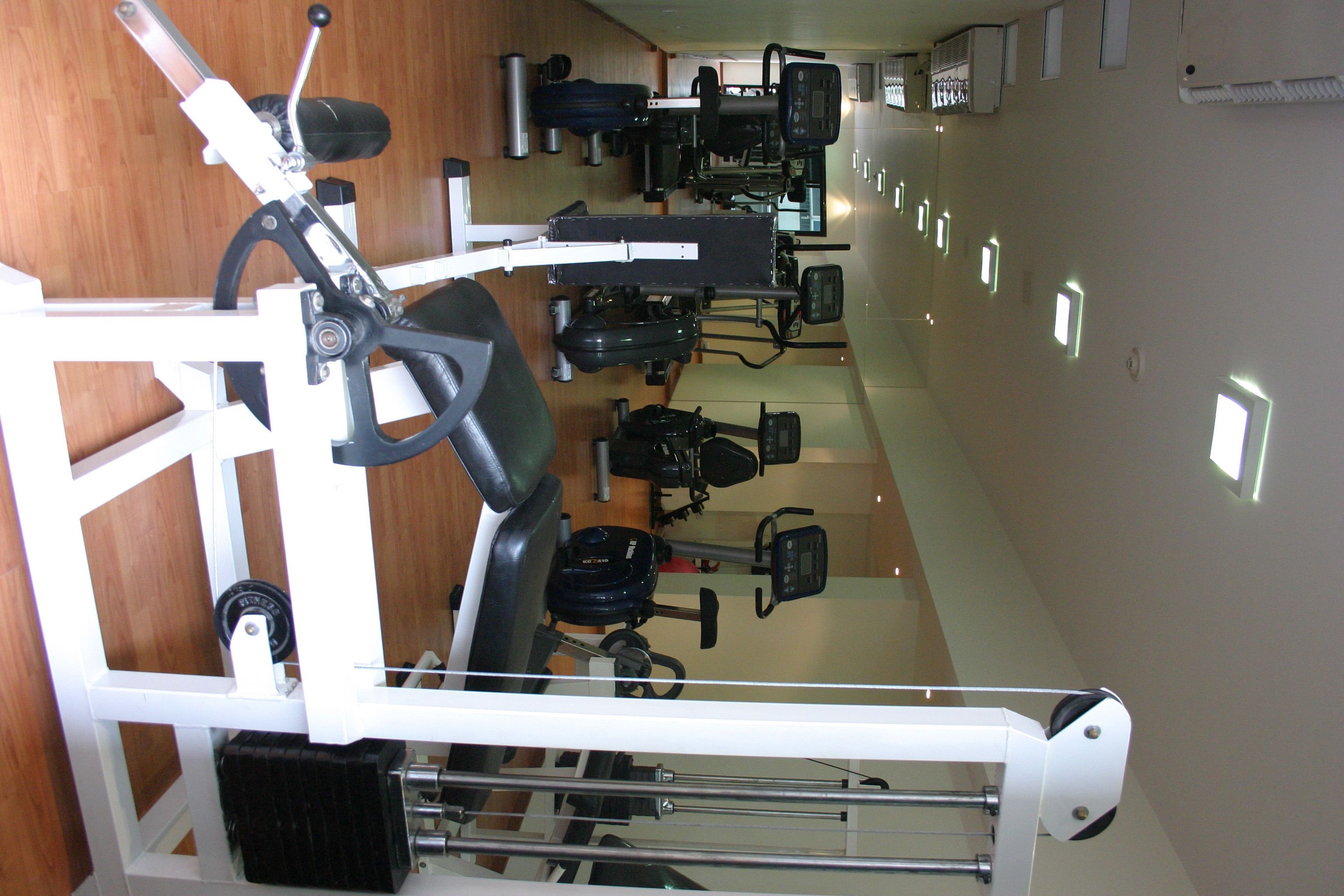 Un gimnasio con diferentes máquinas y equipos de ejercicio.