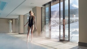 A spacious indoor area with a large glass window overlooking a snowy landscape. - Hotel Lac Salin Spa & Mountain Resort (Livigno)