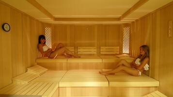 A sauna with wooden benches and a clock on the wall.