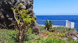 A coastal garden with a rocky backdrop and a view of the ocean. - Rocamar Lido Resort (Santa Cruz)