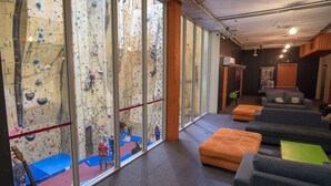 A climbing gym with padded seating and a guitar.
