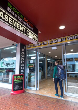 Une devanture de magasin avec une enseigne indiquant « Équipement pour les routards » et « Cinéma souterrain ».