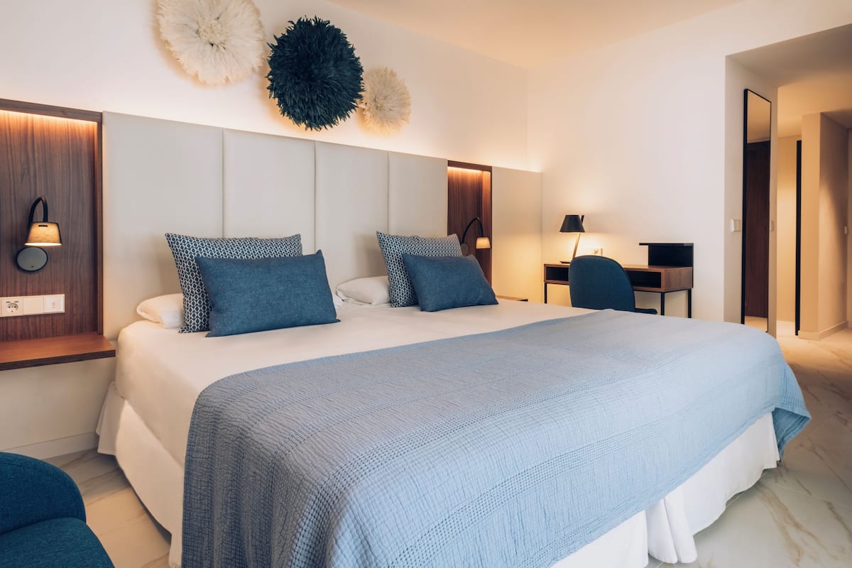 Une chambre d’hôtel moderne avec un grand lit, un bureau et une chaise.