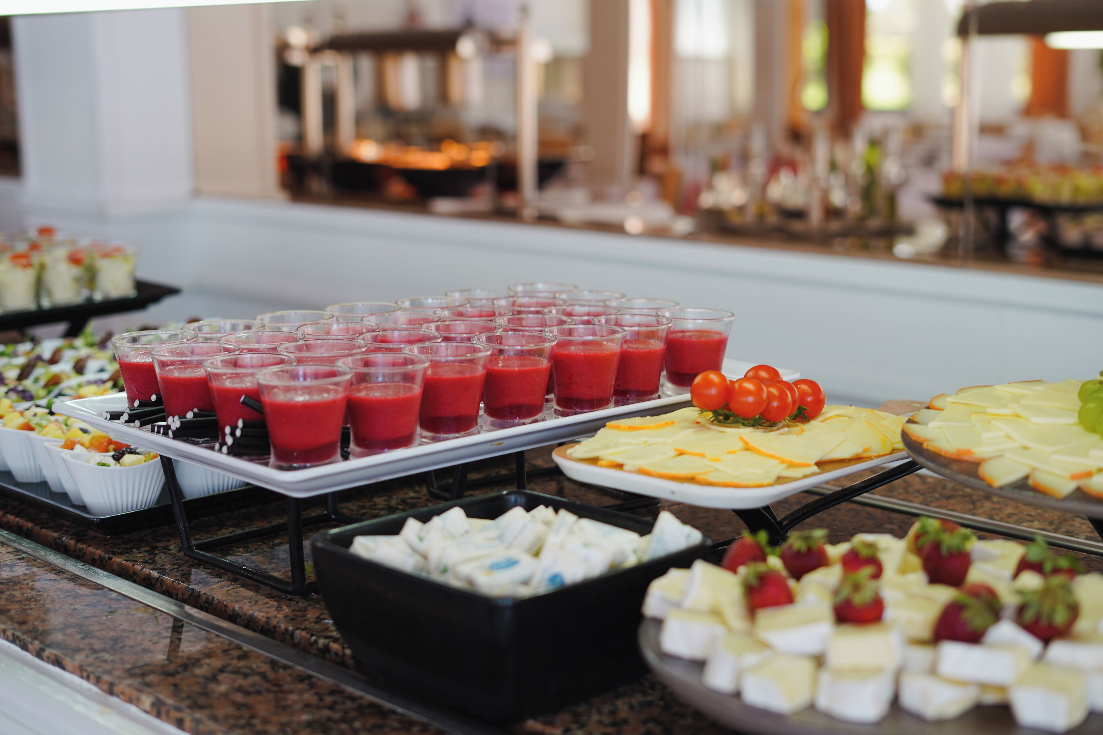 A buffet with various food items including fruit, cheese, and a selection of juices.