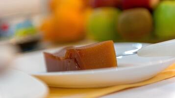 Primer plano de un postre de caramelo sobre un plato blanco con una cuchara.