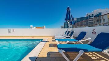Una piscina al aire libre, sombrillas