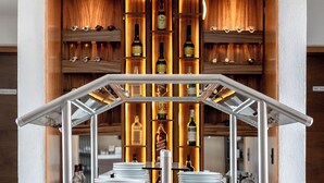 Un espace bar avec un décor en bois, des étagères remplies de bouteilles et une structure de bar en métal.