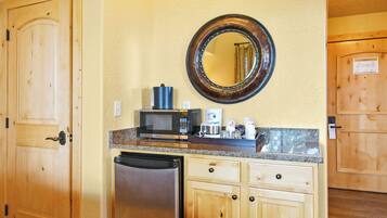 A compact kitchen with a microwave, coffee maker, and stainless steel refrigerator.